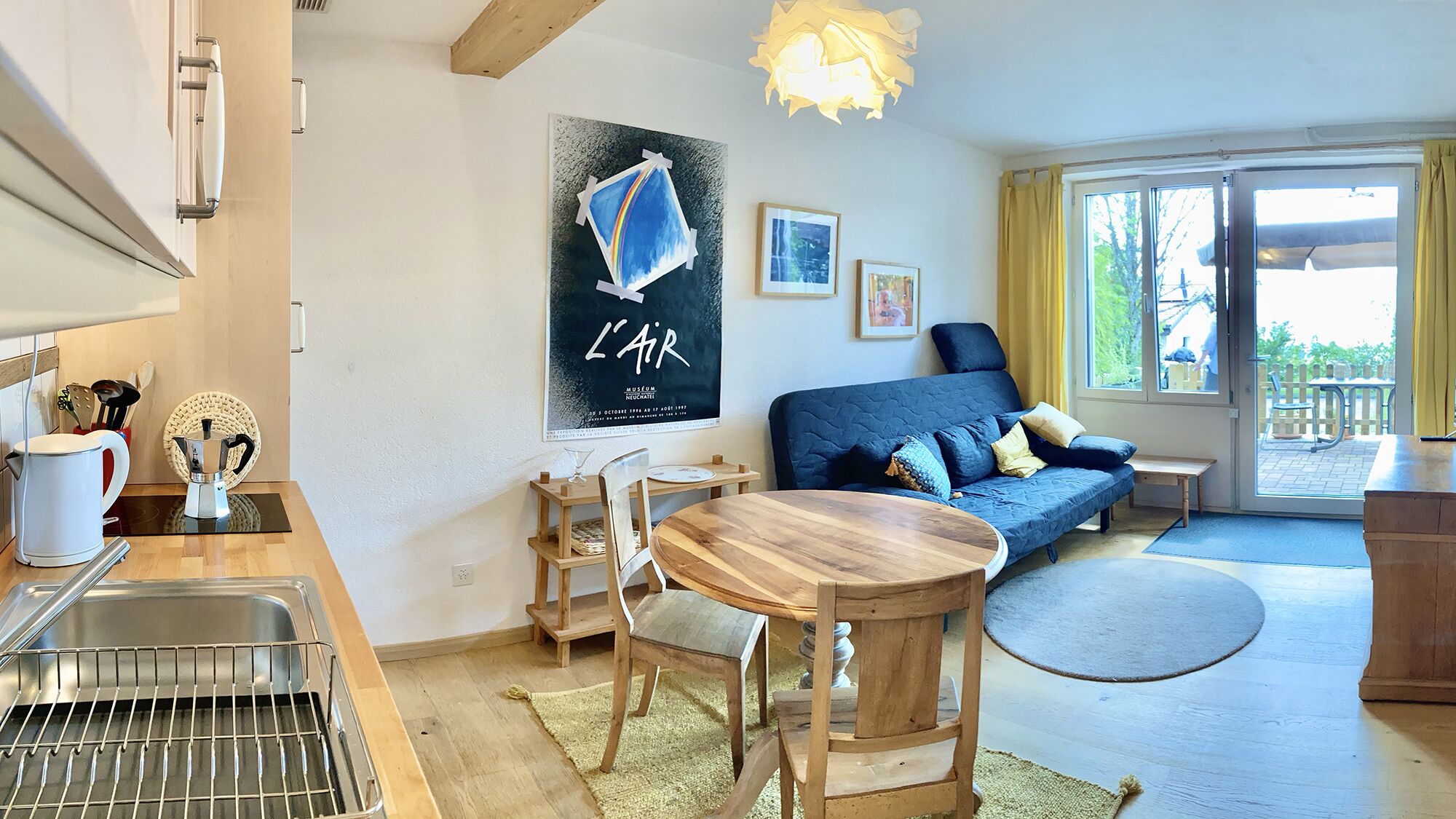 A compact living space with a kitchenette, a dining area, and a sofa.