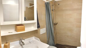 A bathroom with a bathtub, a shower, a sink, and a mirror. - Apartment (Fontainemelon)