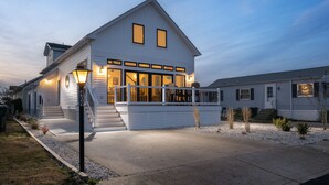 A two-story white house with a covered front porch and a small deck. - Upscale Family Home for 10, Community Pool, Grill (Ocean City)