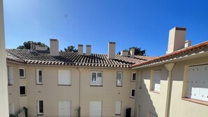 A courtyard with a tiled roof, multiple balconies, and a central open space. - Apartment near beach and shops (Argelès-sur-Mer)