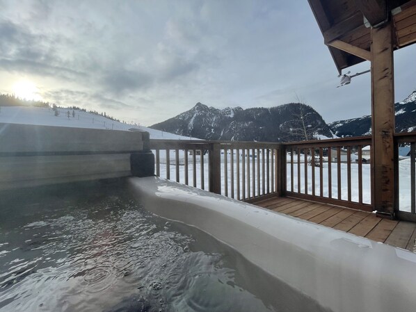Una terraza de madera con vistas a un paisaje nevado de montaña.
