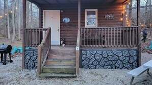 Eine Holzhütte mit Veranda, einer Tür, einem Fenster und einem Schild, das anzeigt, dass es sich um die Hütte Nummer 9 handelt.