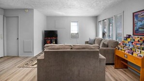 Ein Wohnzimmer mit einer Couch, einem Fernseher und einem kleinen Tisch mit Gegenständen darauf.