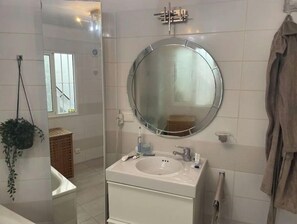 Een bad/douchecombinatie, een bidet, handdoeken, toiletpapier