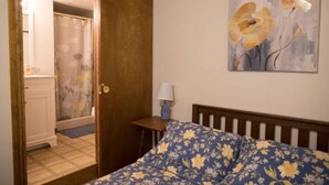 Une chambre à coucher avec un lit, une table de chevet, une lampe et un tableau au mur.