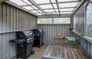 Enjoy al fresco dining in this sheltered outdoor space with barbecue grills and a convenient table.