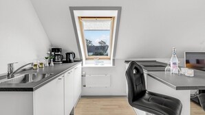 A modern kitchen with a built-in stove, a coffee maker, and a sink. - Cozy apartment in Nexø with WiFi (Nexø)