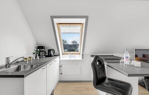 Enjoy a meal in the kitchen with a sink, coffee maker, and kettle, and a dining area with a chair.
