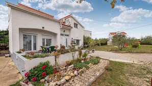 Una casa a due piani con un giardino antistante.