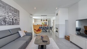 A modern living room with a sofa, a coffee table, and a dining area with chairs and a table. - Beautiful home in Plano (Plano)