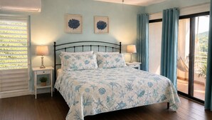 A bedroom with a bed, two bedside tables, a ceiling fan, a window with curtains, and a view of the outdoors. - Updated 1BR/1BA - "Island Sol" with fantastic views (St. Thomas)