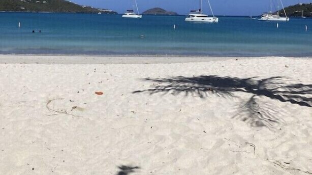 A beach with white sand and clear blue water. There are several sailboats anchored in the distance. - Updated 1BR/1BA - "Island Sol" with fantastic views (St. Thomas)