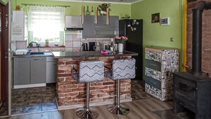 Una cucina moderna con parete a mattoni, mobili grigi e isola centrale con sgabelli da bar.