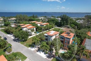 A residential area with houses, a swimming pool, and a view of the ocean.