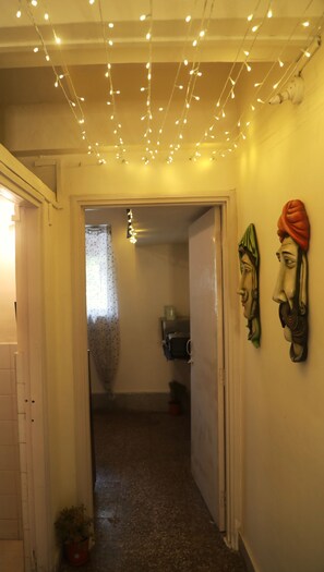 Un pasillo con luces de cuerda, una puerta y dos esculturas en la pared.