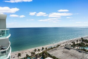 A beachfront hotel with a pool, beach, and ocean view.
