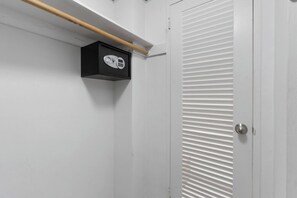 Une porte blanche avec un trou de serrure et une petite boîte noire également dotée d’un trou de serrure, fixée au mur.