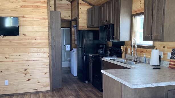 A modern kitchen with wooden cabinetry, a central island, and a built-in refrigerator.