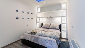 A modern bedroom with a bed, built-in shelving, and a skylight. - 1 bedroom gorgeous apartment in Bakar (Bakar)