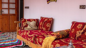 Ein traditionell eingerichteter Raum mit einem Bett, bunten Teppichen und einem Tablett mit Teekanne.