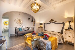 A bedroom with a bed, a sofa, a chair, a nightstand, and a lamp. - GOLD APARTMENT AREZZO CENTER (Arezzo)