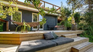 Una terrazza esterna moderna con un divano integrato e un'amaca.
