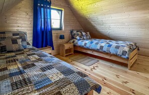 A cozy attic bedroom with two wooden beds, a window with blue curtains, and a small nightstand. - 2 bedroom beautiful home in Mscice (Mscice)