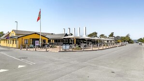 Ein gelbes Gebäude mit einem Schild, auf dem „GALERIE“ steht, und einer Fahnenstange mit einer Flagge.