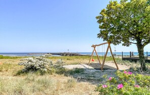 Relax on a sandy path beneath a shaded tree, with a wooden swing nearby.