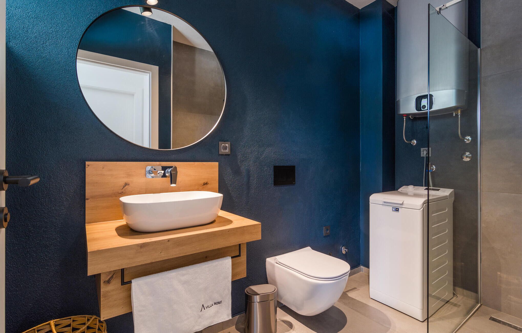 A modern bathroom with a freestanding bathtub, a toilet, and a glass-enclosed shower.