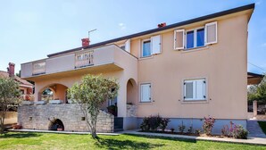 A two-story building with a stone facade, multiple windows with shutters, and a small balcony. - Cozy apartment in Pula with WiFi (Pula)