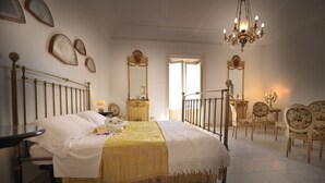 Un dormitorio con cama, mesita de noche y lámpara de araña.