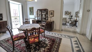 Comedor con una mesa dispuesta para cuatro personas, rodeado de alfombras estampadas y mobiliario de madera.