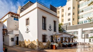 A white building with a stone facade and a sign reading "Casa del Puerto". - Gorgeous home in Marbella with kitchen (Marbella)