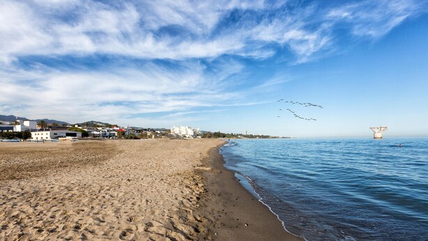 A beach with a clear sky, a sandy shore, and buildings in the background. - Gorgeous home in Marbella with kitchen (Marbella)