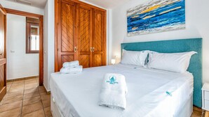 A hotel room with a bed, a wooden wardrobe, and a painting on the wall. - Gorgeous home in Marbella with kitchen (Marbella)