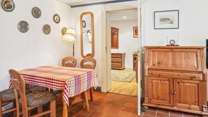 Un comedor con mantel a cuadros, sillas de madera y un aparador.