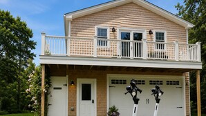 Et toetagers hus med balkon, garage og to elektriske scootere foran.