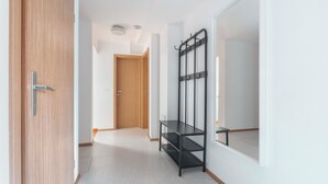 A hallway with a wooden door, a black metal shelf unit, and a large mirror on the wall. - Charming Alpine Retreat – Just Minutes from Lake Bled and Lake Bohinj (Žirovnica)