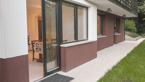 A modern house with large sliding glass doors, a well-maintained lawn, and a clear view of the interior. - Charming Alpine Retreat – Just Minutes from Lake Bled and Lake Bohinj (Žirovnica)