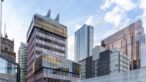 Um edifício moderno com fachada de vidro e estilo arquitetônico clássico.