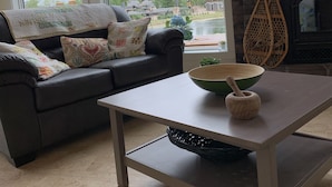 Uma sala de estar com sofá, mesa de centro e lareira.