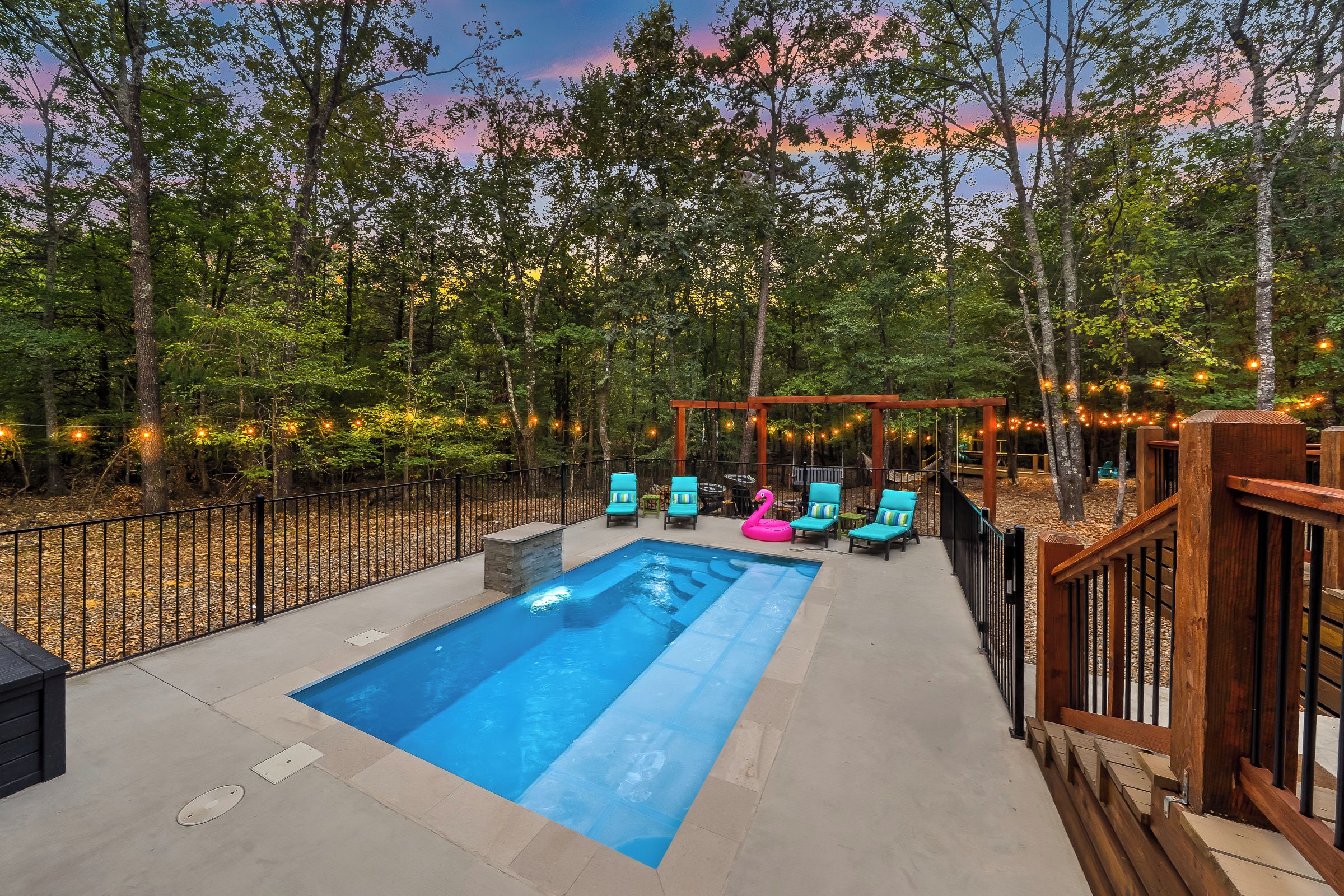 A swimming pool with lounge chairs and a wooden deck.