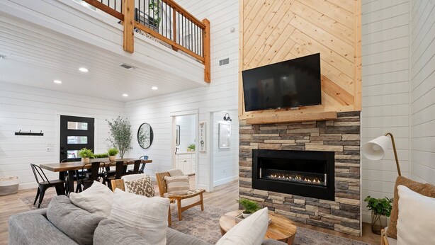 Un espacio habitable amplio con chimenea, un comedor y una escalera que conduce a un nivel superior.