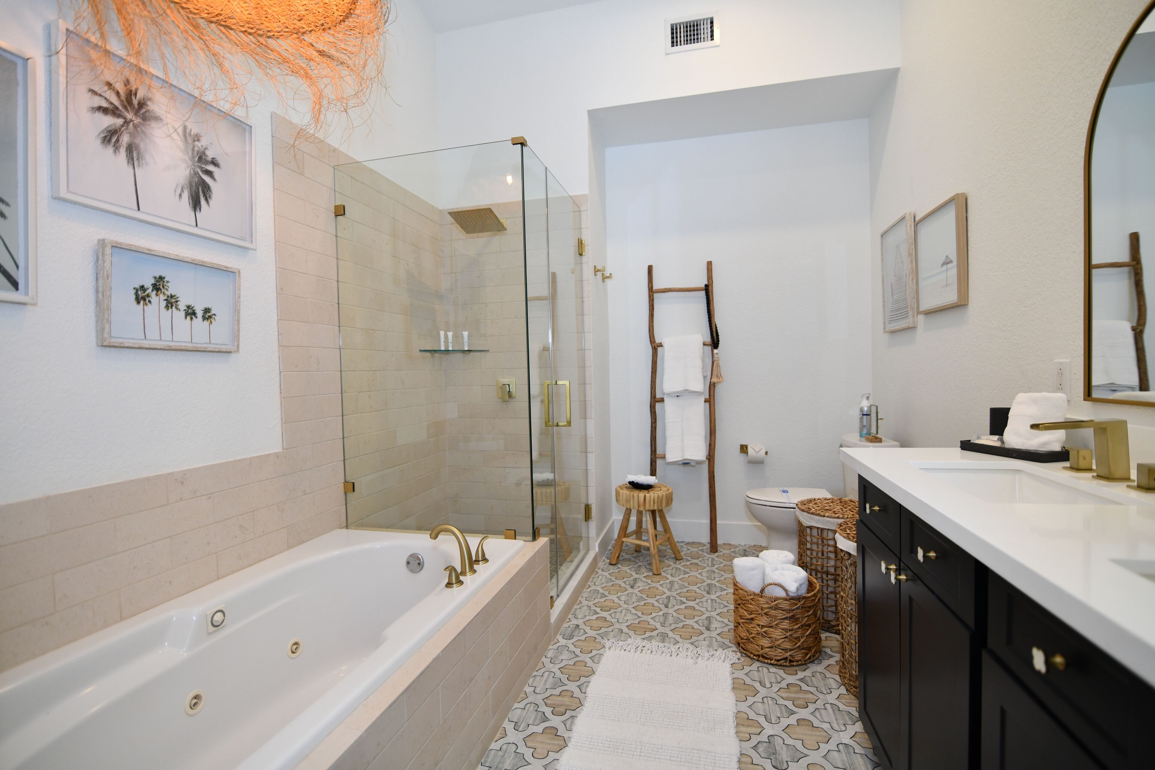 Une salle de bain moderne dotée d’une grande baignoire, d’une douche à parois de verre et d’un meuble-lavabo avec un miroir.