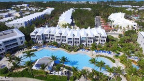 A resort with a central swimming pool, multiple buildings, and a view of the ocean. - Brand New Listing!  Beautiful - Upscale newly remodeled Modern Tropical Oasis! (Key Largo)