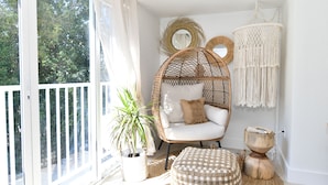 A room with a wicker chair, a round wooden stool, a woven pouf, a potted plant, and a macramé wall hanging. - Brand New Listing!  Beautiful - Upscale newly remodeled Modern Tropical Oasis! (Key Largo)