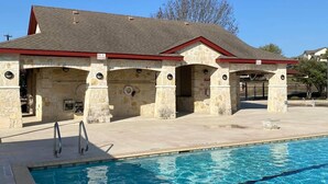Un bâtiment en pierre avec une piscine devant.