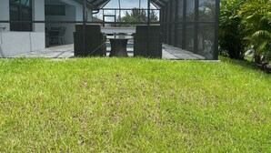 Uma casa moderna com área de varanda envidraçada, mesa de jantar e cadeiras.
