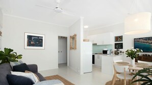 A modern apartment with a living room, kitchen, and dining area.